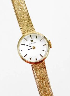 A 9ct gold Tissot ladies cocktail watch, with small silver dial, on a bark effect thin strap, 20cm long overall, the dial 1.5cm wide, 16g all in, boxed.