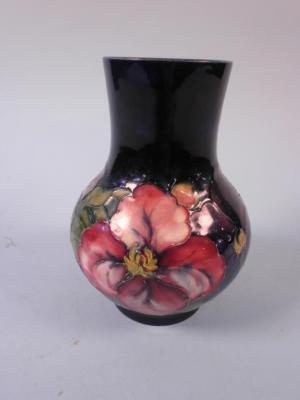 A Moorcroft vase, decorated with the Hibiscus pattern on a navy ground,