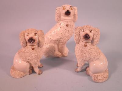 A pair of 19thC Staffordshire poodles with open legs and gilt