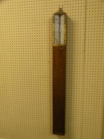 An Edwardian oak and brass stick barometer with ivorine thermometer etc