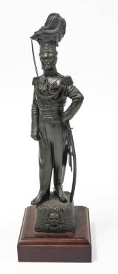 A bronze patinated regimental resin figure of an officer of the 17th/21st Lancers, on a wooden plinth, 42.5cm high, 7cm wide, 6cm deep, the base 4cm high, 13cm wide, 13cm deep.