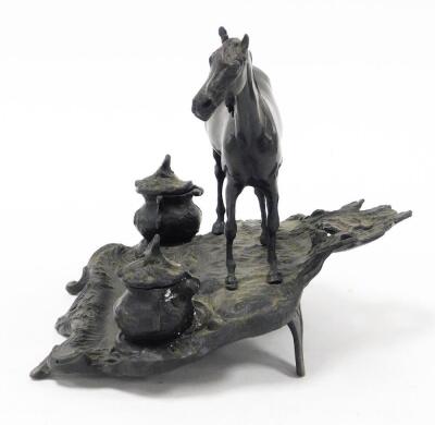 A bronze desk stand mounted as a standing horse, on a rustic stand incorporating two ink recesses and pen rest, with rococo scroll feet, 22cm high. - 2