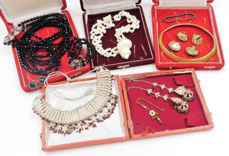 A group of costume jewellery necklaces, to include a three strand shell necklace, a gold plated choker and clip on earrings, an Eastern dress choker with tassel drop, drop earrings, imitation jet bracelet, clip on earrings and necklace, a cultured pearl b