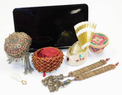 A group of Kailash wedding items, to include a red hat with paste stone drop gold string design set with beads, a cream beaded hat attached fan, a multicoloured wicker storage basket and an Eastern wedding dress set with hat and shirt drops. (a quantity)