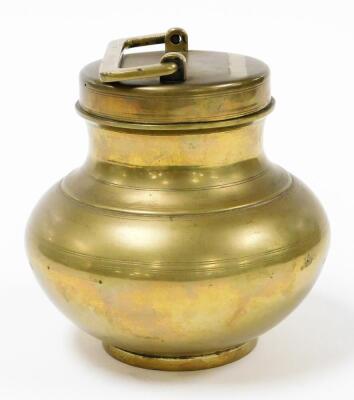 A brass storage canister, the circular fixed top with square handle, on a baluster body with a circular foot, silver coloured to underside, 18cm high. - 2