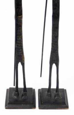 A pair of African bronze tribal sculptures, each of an elongated man with beard and walking stick, on a square tapered base, 66cm high, 6cm wide. (2) - 3