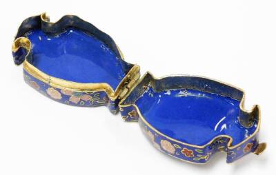 Two oriental cloisonné trinket boxes, the oval example with blue enamel cloisonné decoration on brass, depicting pink and blue flowers 4cm high with lift up lid, the imitation cloisonné urn shaped trinket box, with similar decoration 6cm high. (2) - 8