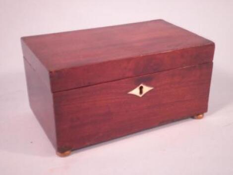 A mid 19thC mahogany tea caddy with brass feet