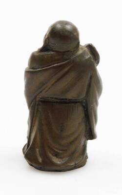 An oriental bronzed metal figure of a buddha, modelled holding a fan, 8cm high. - 3