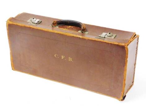 A 20thC leather travelling case, the top bearing initials C.F.B, with lock clasp opening to a blue velvet interior (AF) 47cm wide, 21cm deep, 10cm high.