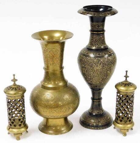 Four Indian brass items, to include a pair of candle stands, with pierced overall detailing, 23cm high, an Eastern brass hammered Asiatic pheasant style vase, 35cm high, and a black and metal and gilt highlighted pheasant stem vase, 41cm high overall. (4)