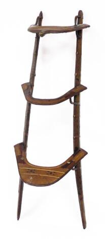 A North African hardwood and brass camel saddle, with three sectional divide, with brass embellishments, 133cm long overall.