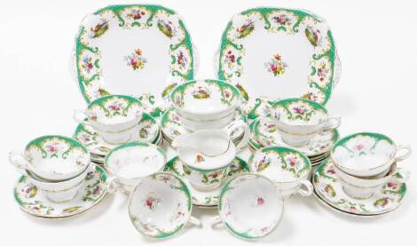 A late 20thC part tea service, decorated in a pattern of green and gold borders with pheasants and flowers, comprising milk jug, sugar bowl, cups, saucers, side plates and a cake plate. (1 tray)