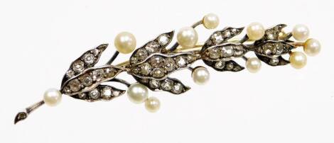 A Victorian diamond and pearl leaf brooch, the brooch formed of a leaf branch with three strand leaves each set with various sized old cut diamonds with cultured pearl ends, in a white coloured back with gold finish, on a later single pin, 7cm wide, gold 