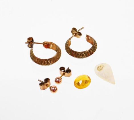 A small group of 9ct gold and other earrings, to include a pair of 9 carat gold hoop earrings, a pair of 9 carat gold studs, 2.2g all in, together with a loose citrine bead and a piece of mother of pearl. (a quantity)