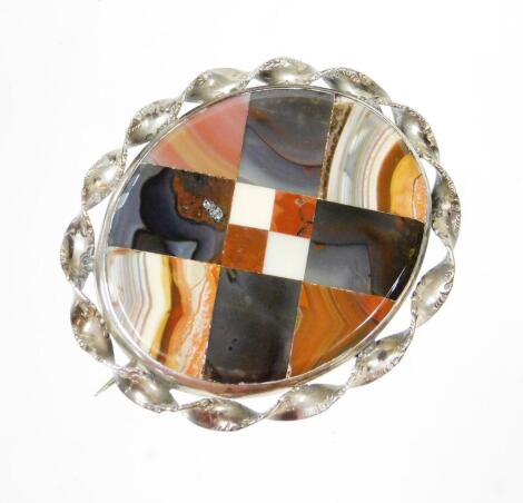 An agate oval broach, in a silver plated weaved frame, the central agate panel with various cut agate sections on a later applied pin back, 5.5cm wide.