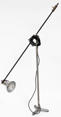 An industrial adjustable floor lamp, on a angle top with shaped shade, on a tripod base, 183cm high.