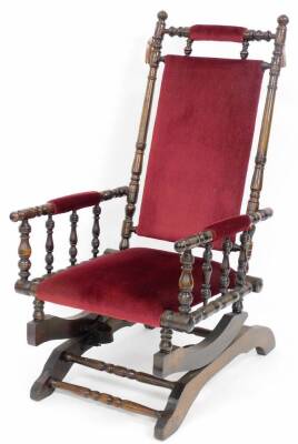 An Edwardian mahogany framed bedroom chair, with red velvet upholstery, on turned supports and rocker base, 102cm high, 40cm wide, 56cm deep.