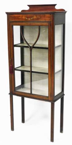 An Edwardian mahogany display cabinet, with marquetry banding, and later painted floral decoration to top, on a shaped cornice, with single astragal glazed door, with a white lined three shelf interior, on tapering legs, 146cm high, 56cm wide, 28cm deep.