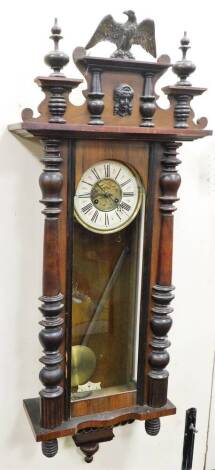 A late 19thC/early 20thC Vienna wall clock, in a walnut case, with reeded pilasters, the dial AF, with a moulded eagle cornice top, 118cm high, 42cm wide, 20cm deep.