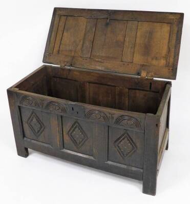 A late 17th/early 18thC oak coffer, the three panelled top section with metal hinges, on a carved two panel front with shield crest and sundial type decoration with a metal lock panel, 59cm high, 107cm wide, 50cm deep. - 2