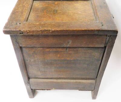 A late 17th/early 18thC oak coffer, the three panelled top section with metal hinges, on a carved two panel front with shield crest and sundial type decoration with a metal lock panel, 59cm high, 107cm wide, 50cm deep. - 4