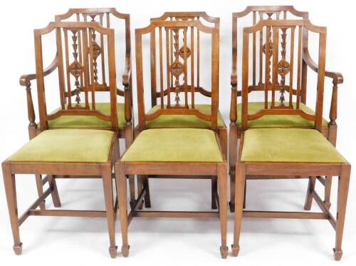 A set of six Edwardian walnut dining chairs, the shaped shield back with central carved floral splats, with drop in green upholstered seats, retail stamp James Beer of Hornsea.