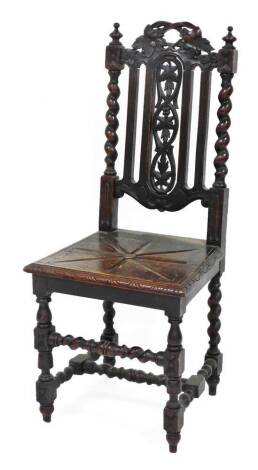 A late 19thC carved oak hall chair, the shield shaped back with barleytwist support columns and leaf and berry carving, with a solid seat, 108cm high, 45cm wide, 42cm deep.