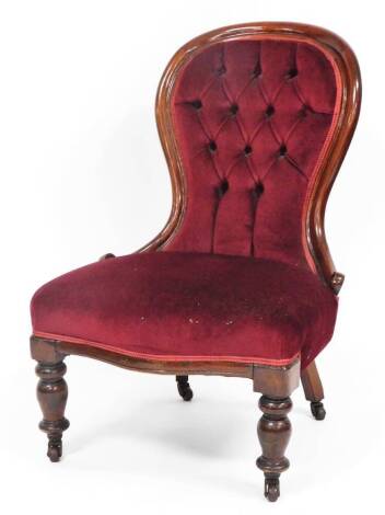 A Victorian button back nursing chair, the mahogany frame with red button velvet seat, on turned legs terminating in castors, 107cm high, 62cm deep.