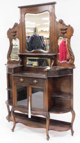 A late 19thC/early 20thC mahogany mirrored back display cabinet, with graduated triple mirror top section and scroll carving with single shelf, with shelf corner unit base with single double astragal glazed display cabinet drawer centre and single drawer,