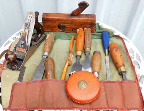 Various wood working tools, to include a wood block plane, stamped F.Atkin, 23.5cm wide, a Stanley number 4 Bailey wood plane, 24cm wide, and a set of wooden handled chisels, stamped Harkells & Sons Caswell, and a Rayburn Chesterton limited tape measure. 