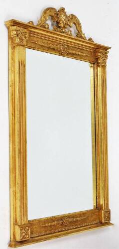 An early 20thC gilt framed wall mirror, with rectangular mirror plate on Corinthian column surround with scroll feather top, 83cm high x 66cm wide.