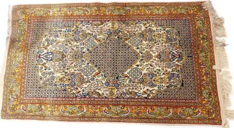 A Tabriz design Iranian wool rug, on a cream ground, with central blue medallion, flowers and bird border, on a cream tassel end, 180cm x 105cm.