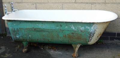 A Victorian cast iron and enamel bath, of bull nose shape on heavy cast hairy paw feet, with two taps and plug, 160cm long.