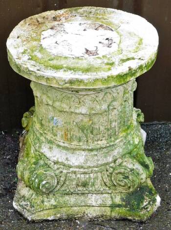 A reconstituted stone plinth, formed as an inverted Corinthian type capitol, 39cm high, 33cm wide.