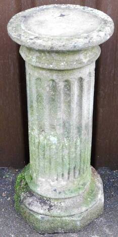 A reconstituted stone garden plinth, the circular top over a reeded column, on a stepped base, 65cm high, the top 28cm diameter.