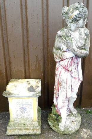 A painted stone garden ornament of Pomona, Greek Goddess of Fruits, the woman in red painted robe, on a vine and flowers stepped base, figure 117cm high, base 44cm high.