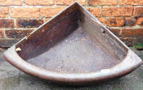 A cast iron corner feeding trough, 70cm high, 90cm deep.