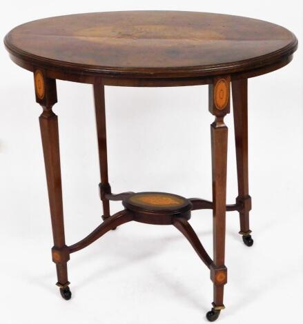 An Edwardian parquetry and mahogany Sheraton revival inlaid sofa table, the oval top with large shell parquetry inlay, on tapered legs, with a oval cross section base with shell terminating in castors, 70cm high, 77cm wide, 57cm deep.