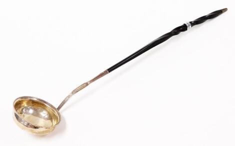 A George III silver punch ladle, on a turned ebony handle, bears the crest marks Sine Labe Nota and a seated greyhound and rubbed initials, London 1787, 34cm long overall.