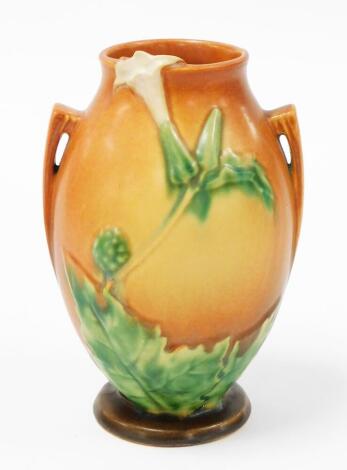 An early 20thC Roueville art pottery vase, on a terracotta coloured base, with dandelion decoration, and two handles, 23cm high.