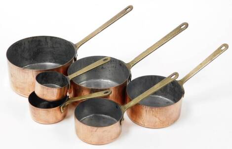 An early 20thC graduated set of six copper saucepans, the largest 17cm diameter, the smallest 7cm diameter, on copper handles.