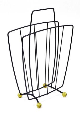 A 1960's/70's magazine rack, with metal design, on yellow ball feet, with carrying handle, 44cm high, 30cm wide, 10cm deep.