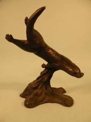 A bronze resin sculpture in the form of a diving otter on a shaped base