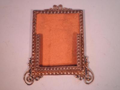 An Edwardian silver frame or desk calendar with a beaded border and ribbon crest