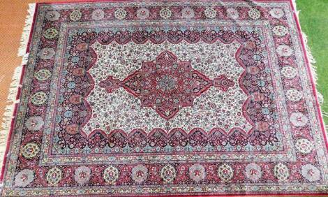 A Tabriz design carpet, the central medallion panel on a red cream and blue ground, with flowers, bearing label Tubris Super 100% Rerne Woole, No 5895, 340cm x 252cm.