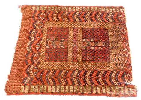 A Turkoman type rug, with a geometric design in navy blue, red, etc., on a red ground with multiple borders, (AF), 135cm x 116cm.