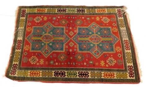 A Kazak` type rug, with two turquoise and red geometric medallions, on a red ground with one wide and various narrow borders, 146cm x 100cm.