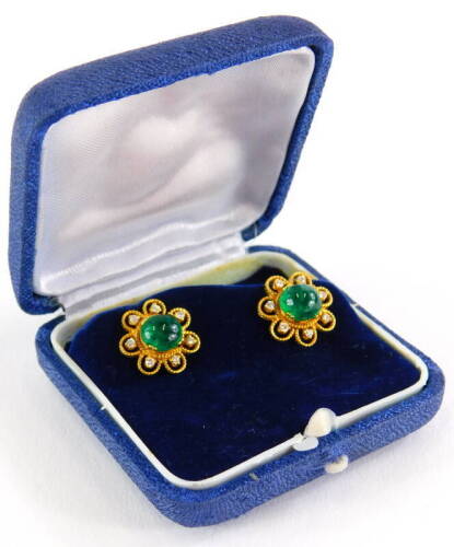 A pair of emerald and diamond cluster earrings, each set with central cabochon cut emerald with seven point flower surround, in rope twist design border, on a screw on butterfly back, yellow metal, the backs marked 18kt, earring head 1.4cm wide, 7.2g all