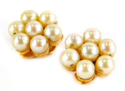 A pair of pearl earrings, each in a cluster group, with seven pearls, in a yellow clip on metal frame, unmarked, 3.7g all in.